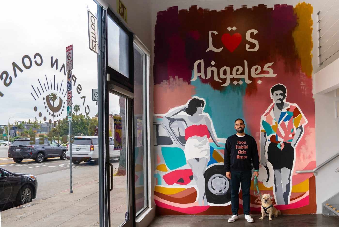 Rahi, founder of Caspian Coast Coffee, in front of the LÖS Angeles mural in Venice